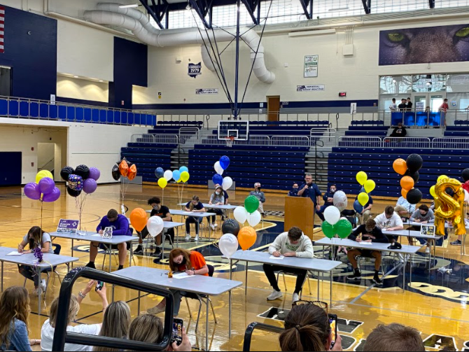 The+senior+athletes+sign+at+the+college+signing+ceremony.