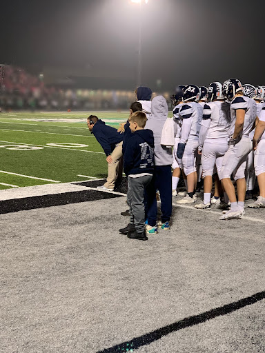 Coach on the sidelines with his team. 