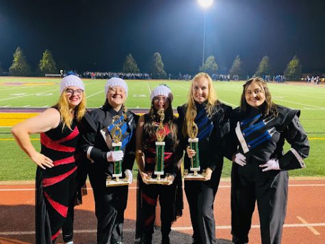 Drum majors holding trophies from the competition.