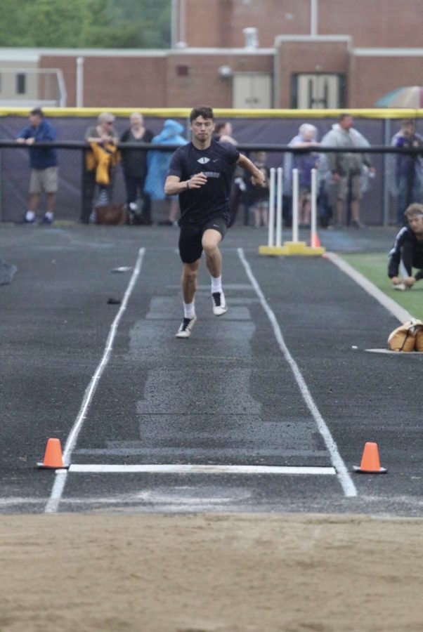 Brick Barker competing in long jump at the 2021-22 Track & Field Districts meet