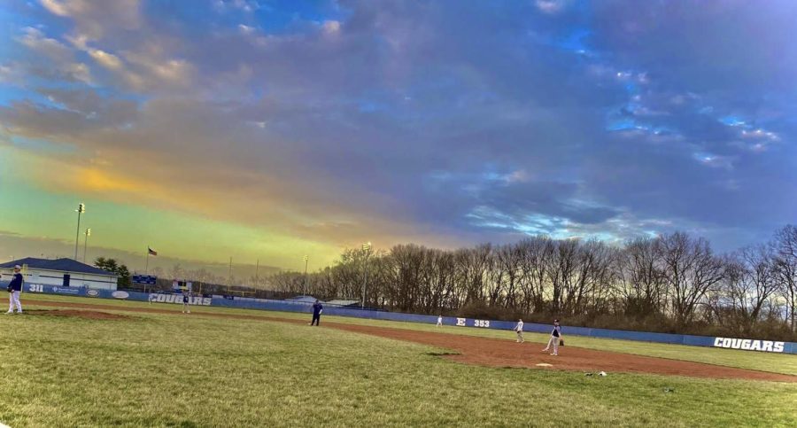 The baseball team practices on a beautiful evening.  