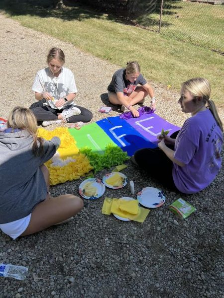 Juniors (L to R) Lilly Fryman, Olivia Day, Grace VandeRyt and Cora Morris work on pomping a sign for the junior float.  