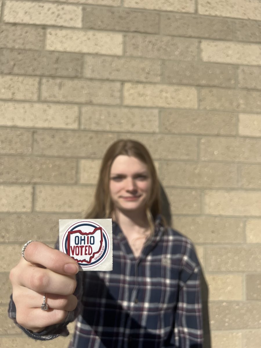 Skyla Esselborn is showing off an “Ohio Voted” sticker preparing to cast her ballot for the first time. 