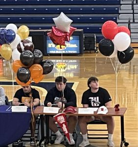 Seniors, Brayden FItzwater, Declan Hitte, and Brycen Robertson all sitting next to each other during EHS signing day.