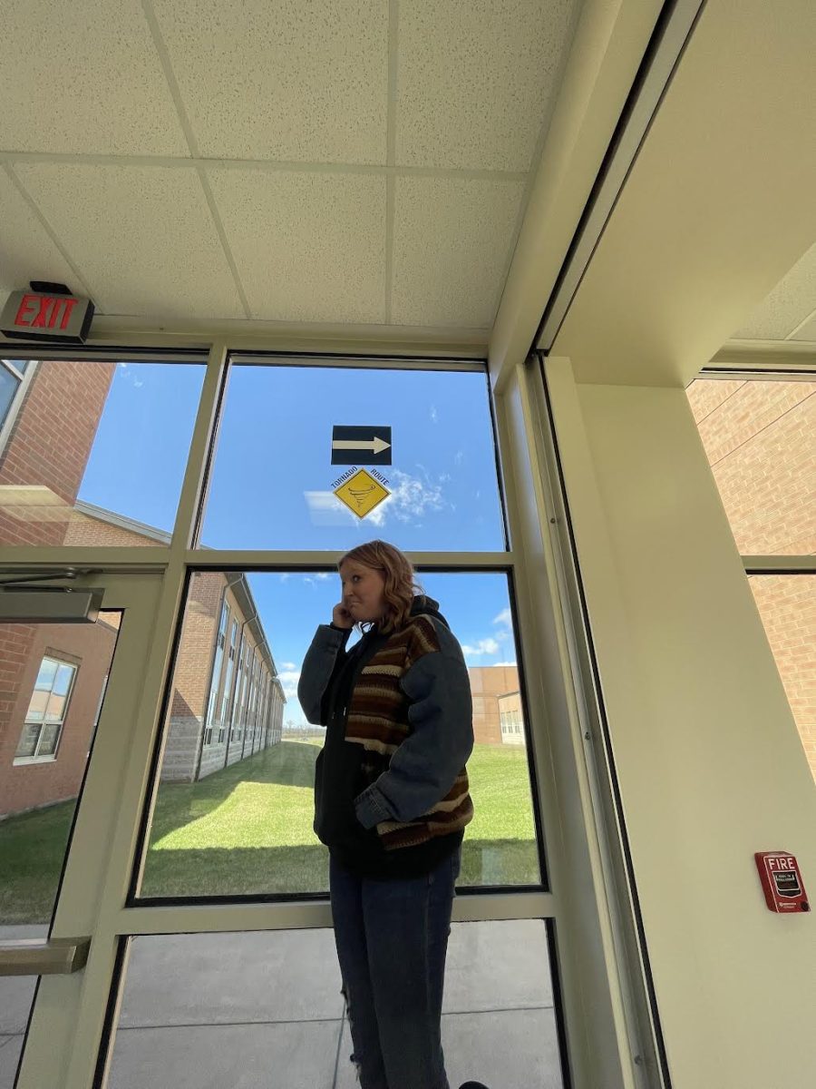 Freshman Mariah Sparks under the tornado route signs at EHS.  