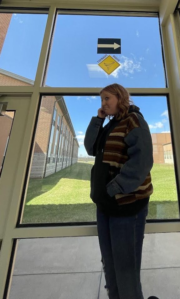 Freshman Mariah Sparks under the tornado route signs at EHS.  